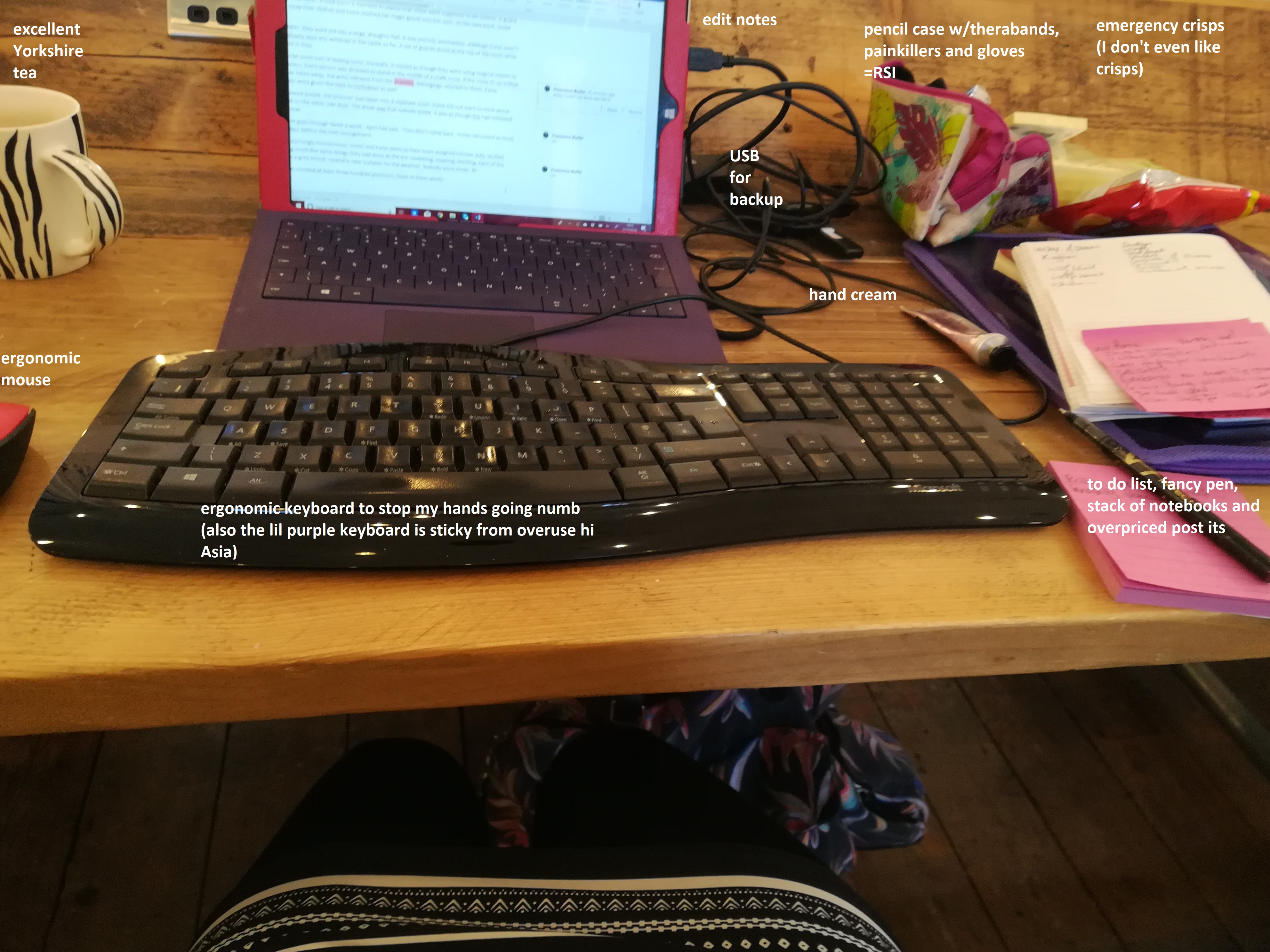 writer's laptop set up with extra mouse, keyboard, notebooks