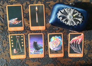 clutch bag next to 6 Raven's Prophecy tarot cards